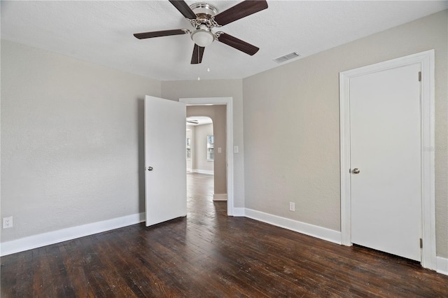 unfurnished room with ceiling fan and dark hardwood / wood-style flooring