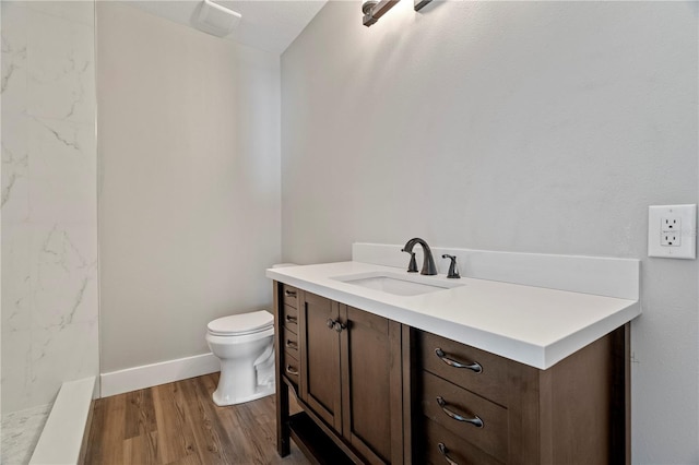 bathroom featuring vanity, wood-type flooring, and toilet