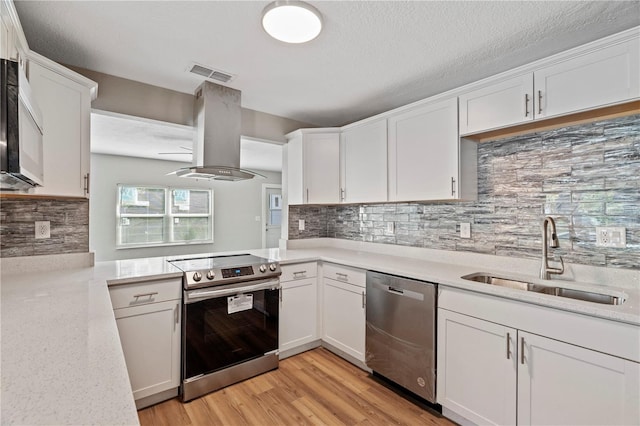 kitchen featuring island exhaust hood, decorative backsplash, sink, white cabinets, and appliances with stainless steel finishes