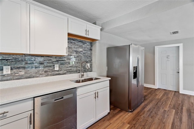 kitchen featuring decorative backsplash, dark hardwood / wood-style floors, sink, white cabinetry, and appliances with stainless steel finishes