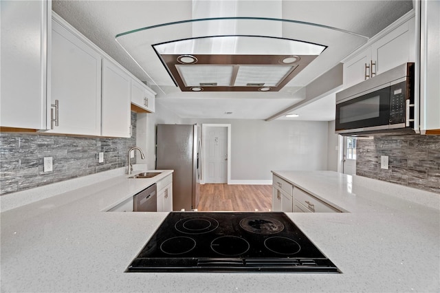 kitchen with decorative backsplash, light stone counters, appliances with stainless steel finishes, white cabinetry, and sink