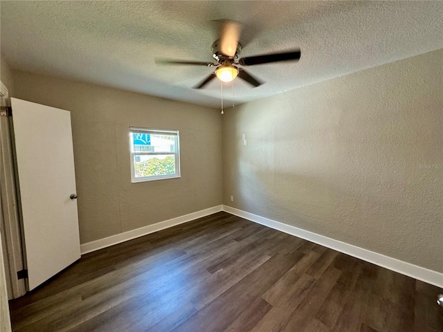 spare room with dark hardwood / wood-style floors, a textured ceiling, and ceiling fan