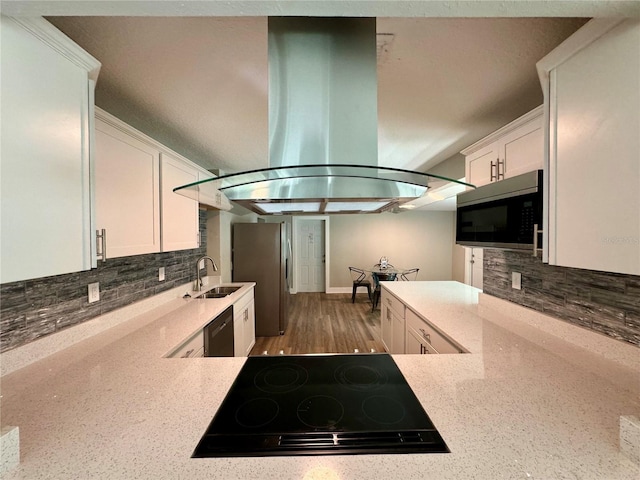 kitchen featuring white cabinets, black appliances, island range hood, and backsplash