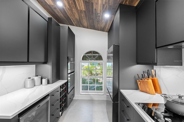 kitchen featuring wood ceiling, tasteful backsplash, beverage cooler, light stone countertops, and stainless steel appliances