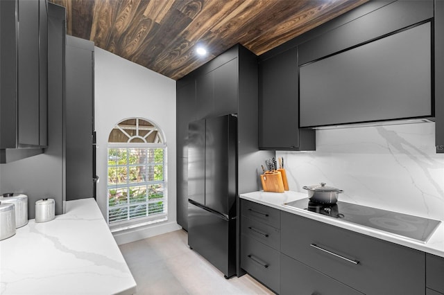 kitchen with decorative backsplash, stainless steel fridge, light stone countertops, wooden ceiling, and black electric cooktop