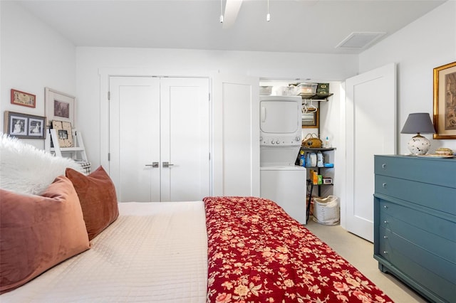 carpeted bedroom featuring stacked washer / dryer