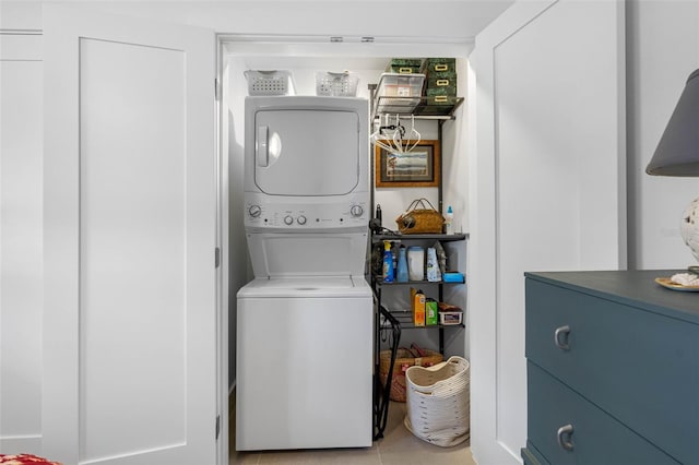 washroom with stacked washer / dryer and light tile patterned floors