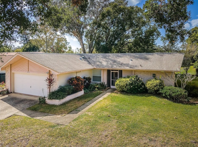 ranch-style house featuring an attached garage, a front yard, roof with shingles, stucco siding, and driveway