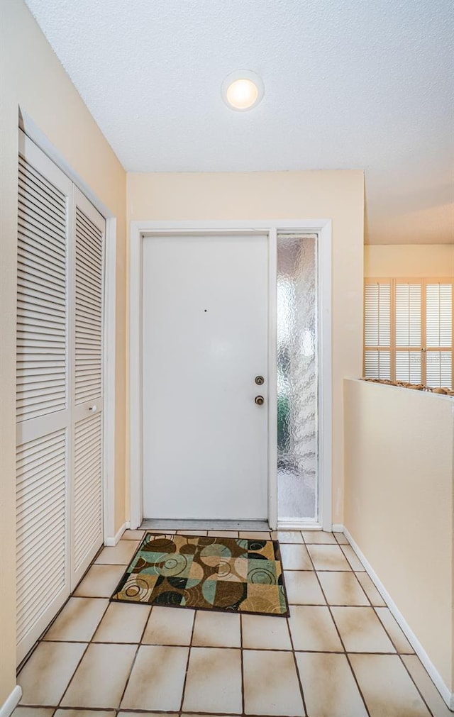 interior space with a wealth of natural light, baseboards, and light tile patterned flooring