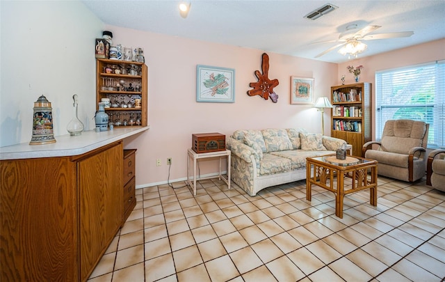 living area with visible vents, baseboards, and a ceiling fan