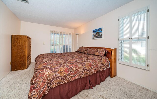 carpeted bedroom with a textured ceiling