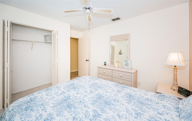 carpeted bedroom featuring visible vents, a closet, and ceiling fan