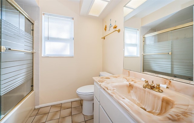 bathroom with tile patterned flooring, vanity, toilet, and a healthy amount of sunlight