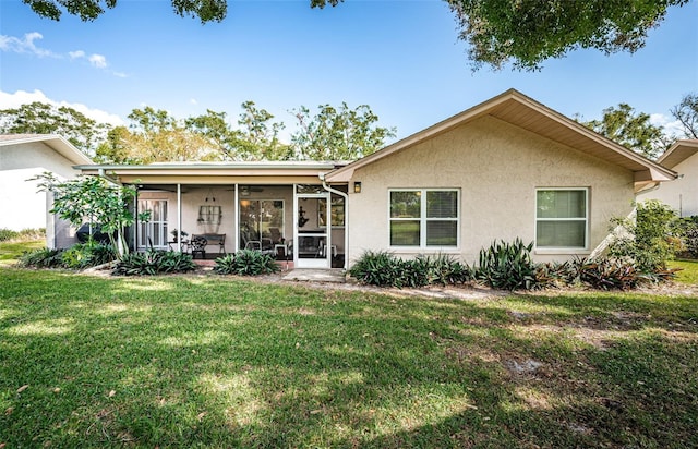 view of front of property with a front lawn, a sunroom, and stucco siding