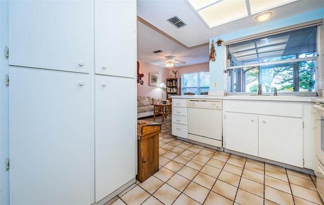 kitchen with visible vents, dishwasher, light countertops, light tile patterned floors, and white cabinets