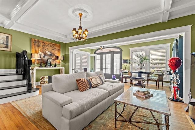 living room featuring beamed ceiling, coffered ceiling, hardwood / wood-style flooring, and a chandelier