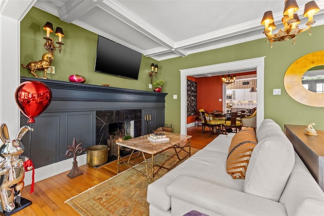 living room featuring crown molding, a high end fireplace, hardwood / wood-style flooring, and beamed ceiling