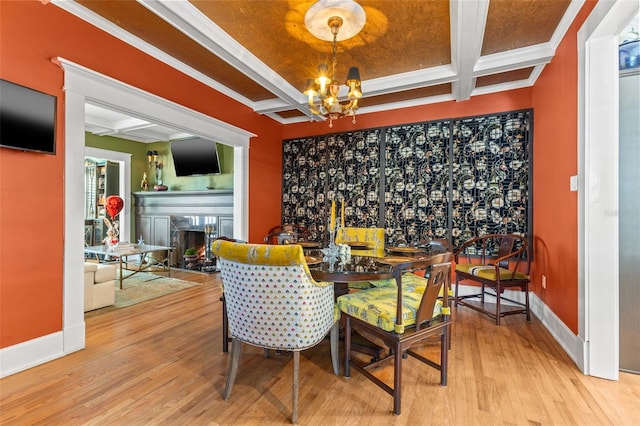 dining space featuring hardwood / wood-style floors, beam ceiling, ornamental molding, a notable chandelier, and coffered ceiling