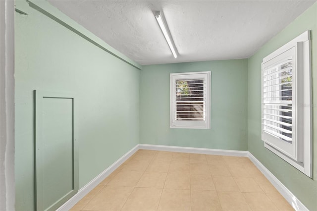 tiled spare room featuring a textured ceiling