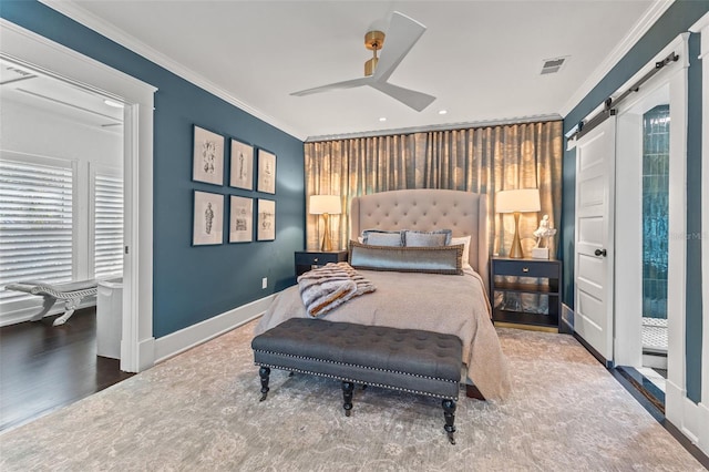 bedroom featuring crown molding, hardwood / wood-style floors, a barn door, and ceiling fan