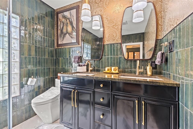 bathroom with vanity, tile walls, and toilet