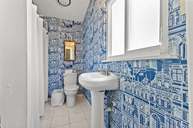 bathroom featuring toilet, tile patterned floors, and tile walls