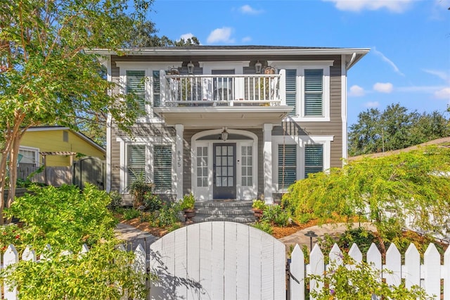 view of front of house featuring ceiling fan and a balcony