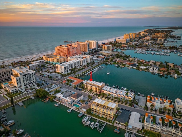 aerial view at dusk featuring a water view