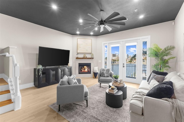 living room featuring light wood-type flooring and ceiling fan