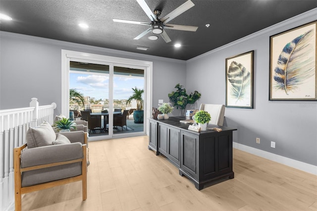 office space with crown molding, light hardwood / wood-style flooring, a textured ceiling, and ceiling fan