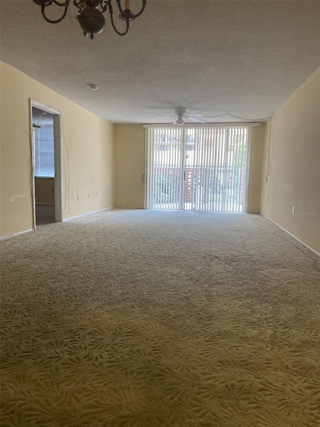 empty room with a textured ceiling, carpet, and ceiling fan