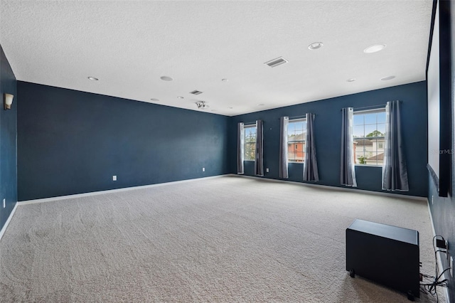 carpeted spare room featuring a textured ceiling