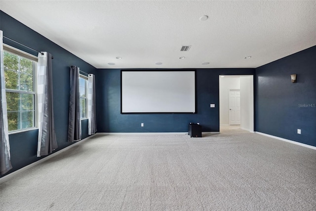 carpeted home theater room with a textured ceiling