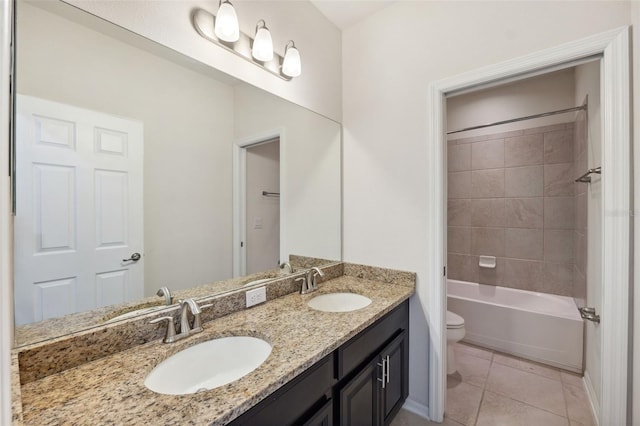 full bathroom featuring vanity, tile patterned flooring, toilet, and tiled shower / bath