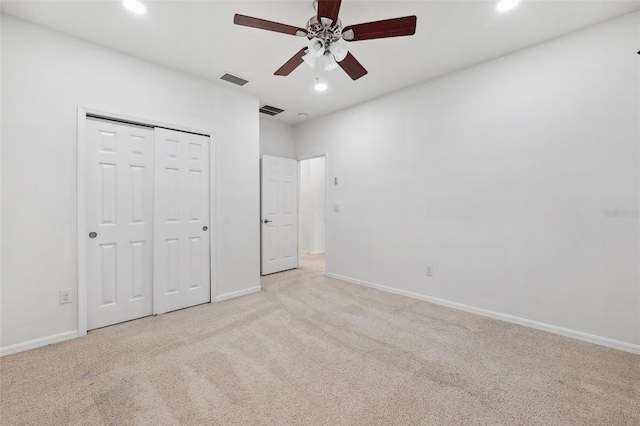 unfurnished bedroom featuring ceiling fan, light carpet, and a closet