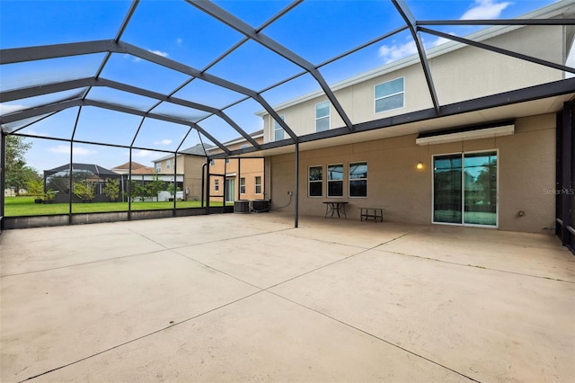 back of property with central air condition unit, glass enclosure, and a patio