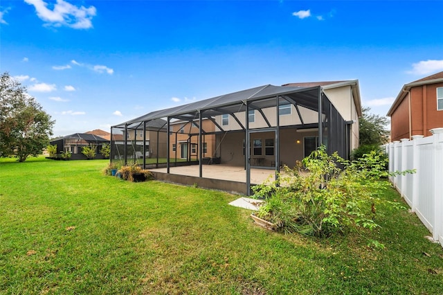 back of property with a lanai, a lawn, and a patio area