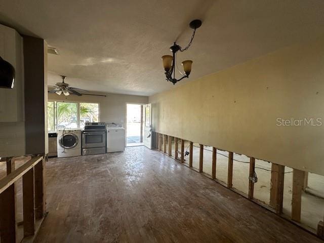 interior space with hardwood / wood-style floors, ceiling fan with notable chandelier, and separate washer and dryer