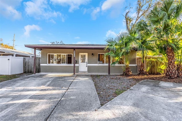 single story home with covered porch, fence, and stucco siding