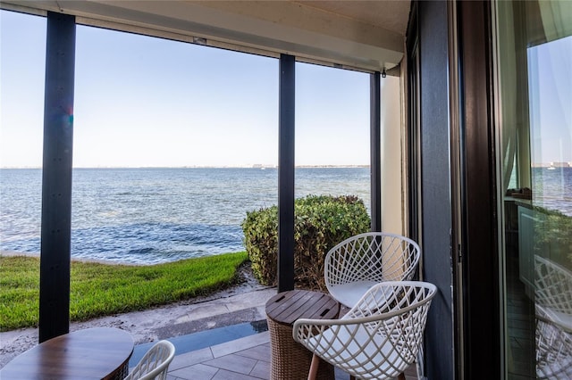 sunroom featuring a water view