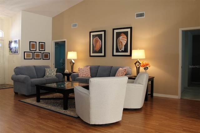 living room featuring high vaulted ceiling and wood-type flooring