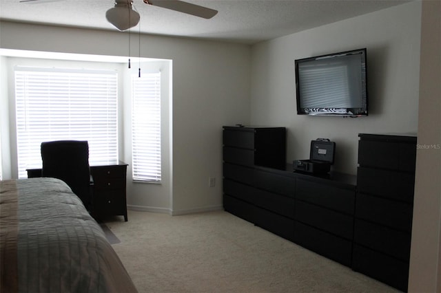 bedroom with ceiling fan, a textured ceiling, and light colored carpet