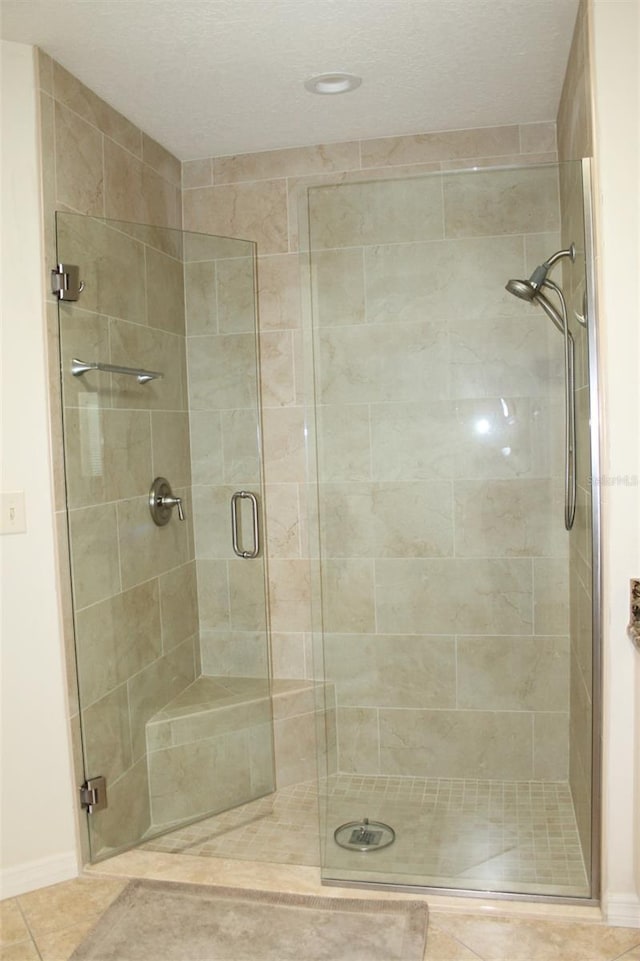 bathroom with walk in shower and tile patterned flooring