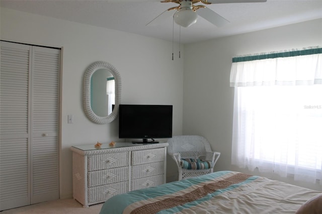 carpeted bedroom featuring a closet and ceiling fan