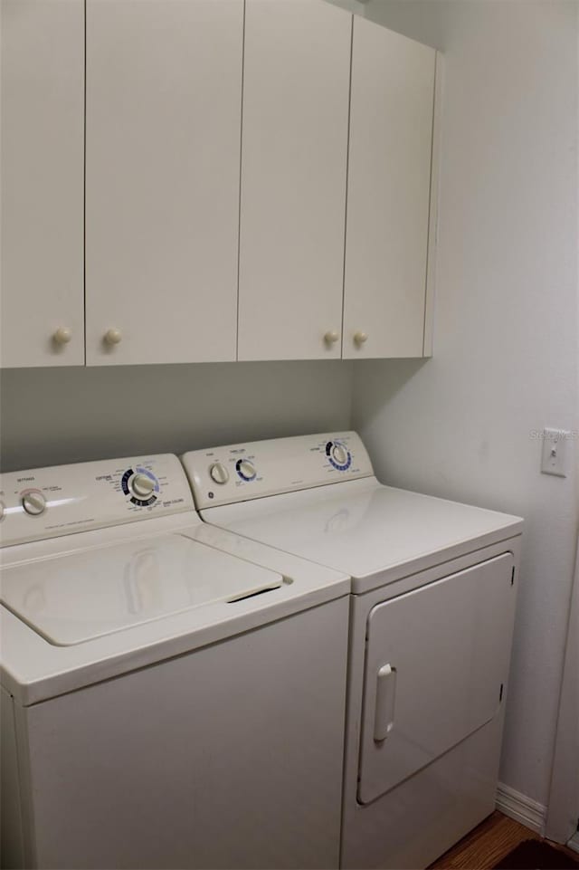 washroom with washing machine and dryer and cabinets