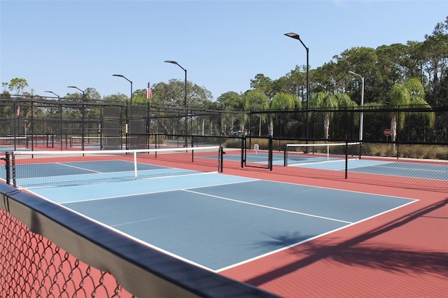 view of tennis court with basketball hoop