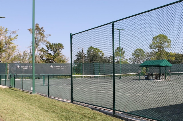 view of tennis court featuring a yard