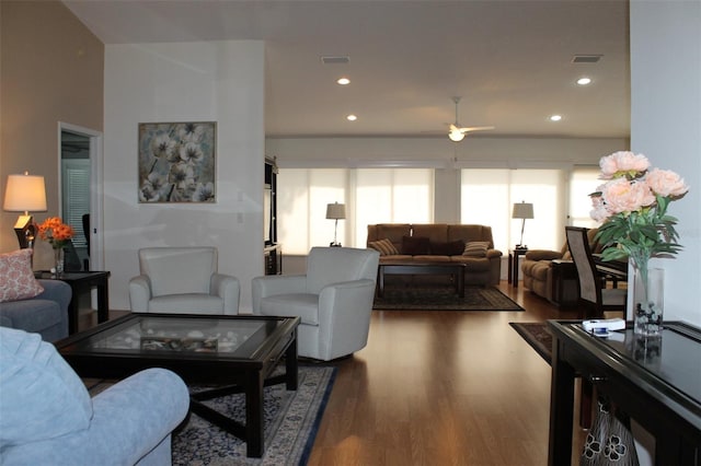 living room featuring ceiling fan and dark hardwood / wood-style flooring