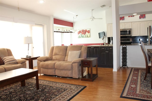 living room with light hardwood / wood-style floors and ceiling fan