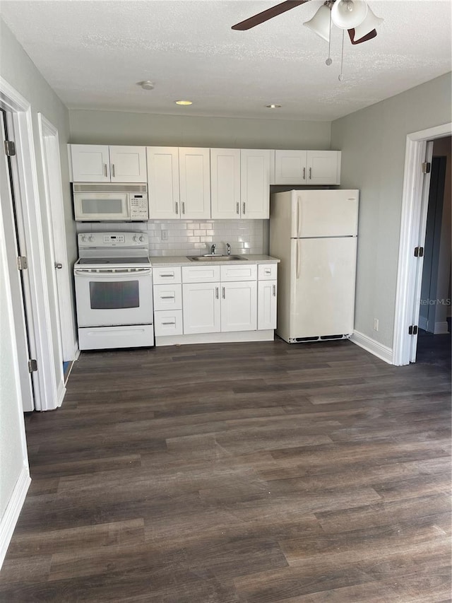 kitchen featuring white cabinetry, dark hardwood / wood-style floors, backsplash, and white appliances